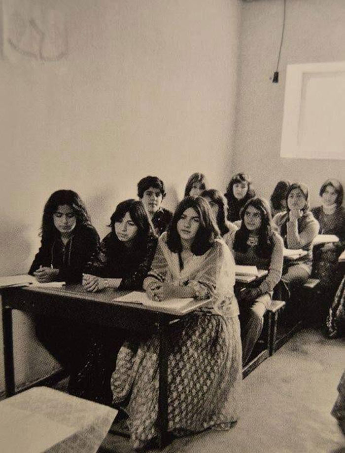 Students sitting in a '70s high school classroom, focused on their studies.