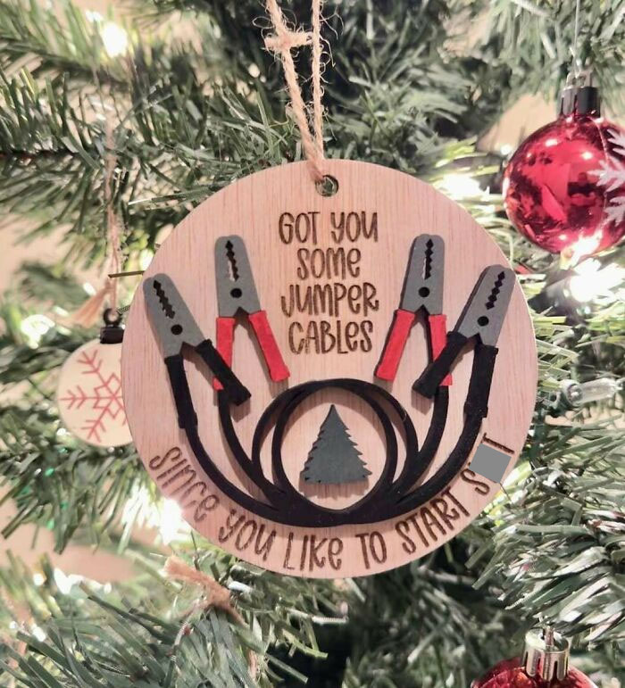 Hilarious trolling Christmas gift ornament with jumper cables on a festive tree.