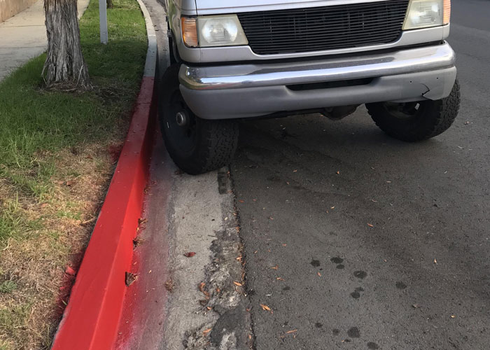 Truck parked with tire on red curb, symbolizing HOA fake violations dispute. Truck parked with tire on red curb, symbolizing HOA fake violations dispute.