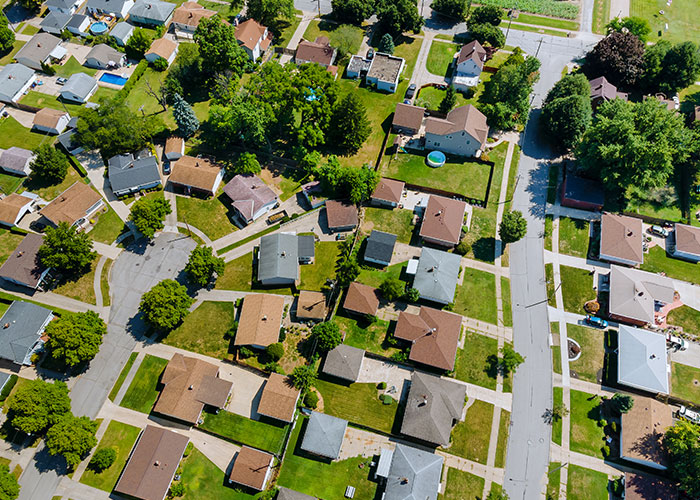 Aerial view of suburban neighborhood, topic relates to HOA and fake violations. Aerial view of suburban neighborhood, topic relates to HOA and fake violations.