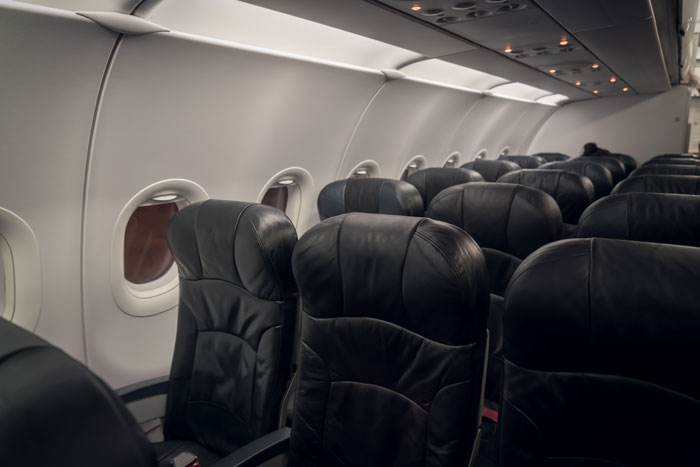 Empty airplane seats in the aisle.