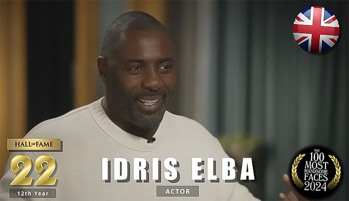 Actor in cream sweater, featured among 2024's most handsome men by The Independent Critics, smiling warmly in an interview.