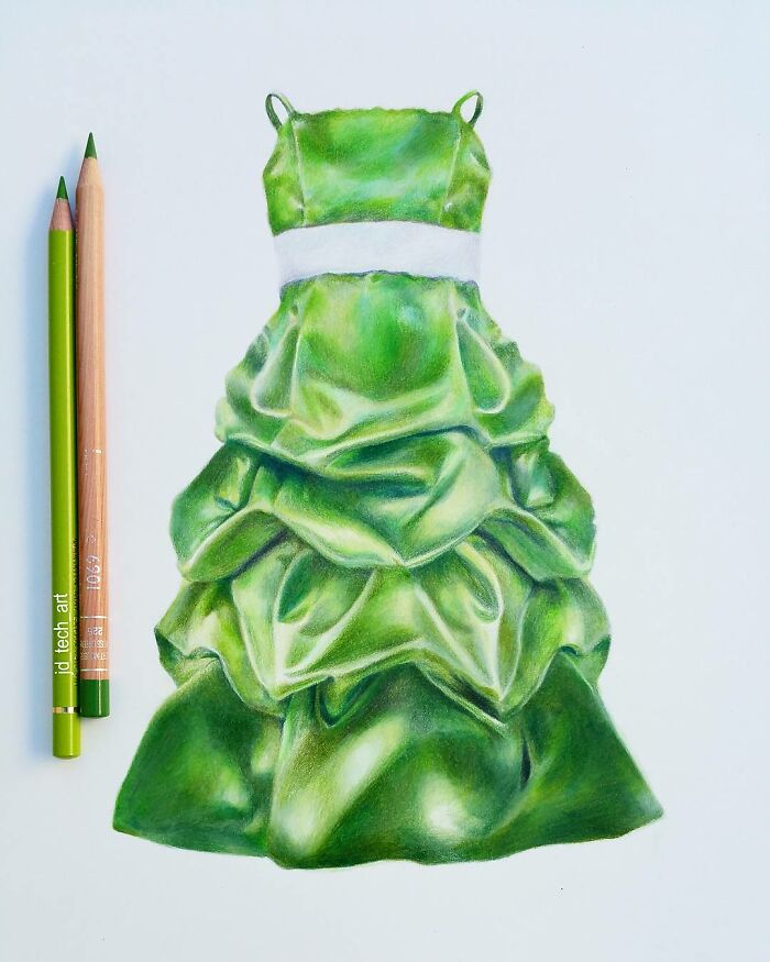 Hyper-realistic pencil drawing of a green dress, showcasing artistic detail and texture, alongside green pencils.
