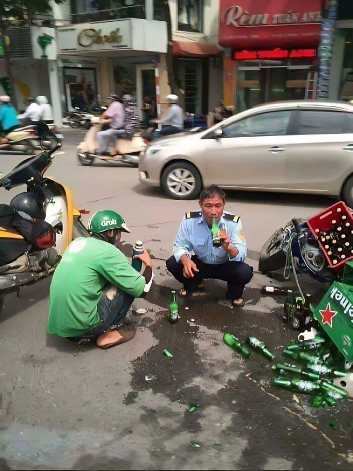 Two men sitting on a street amidst spilled beer bottles, a scene reminiscent of a potential album cover image.