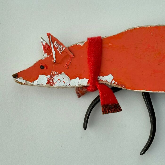 Driftwood animal sculpture resembling a fox, with a red scarf, showcasing unique artistry by Kirsty Elson.