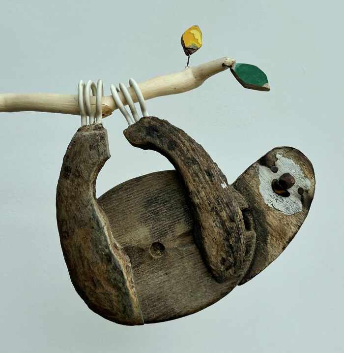 Driftwood animal sculpture of a sloth by Kirsty Elson, hanging from a branch.