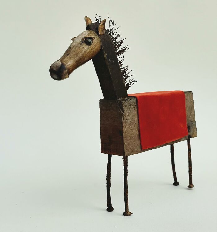Driftwood animal sculpture of a horse with a red saddle, created by artist Kirsty Elson.