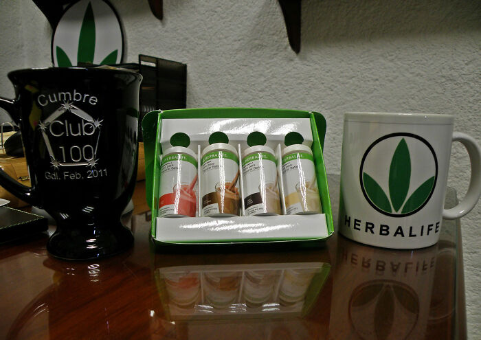 Herbalife products displayed with branded mugs, representing controversial industries.