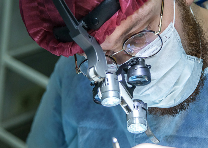 Surgeon focused on precision work, showcasing real-life insurance challenges in medical procedures.