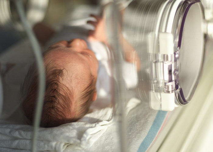 Newborn baby in an incubator, highlighting real-life insurance challenges.
