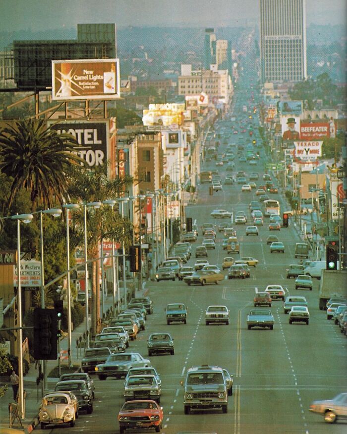 A busy 1970s West Coast city street, filled with vintage cars and retro signage, showcasing the era's iconic urban vibe.
