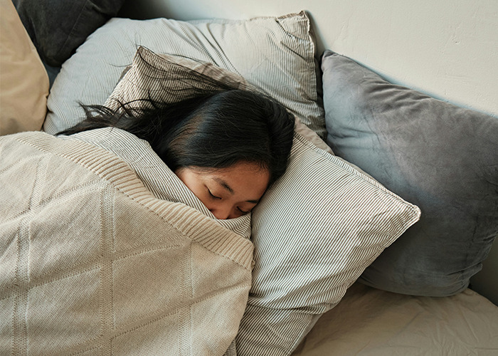 Person sleeping in a cozy bed, illustrating a health hack for better rest.