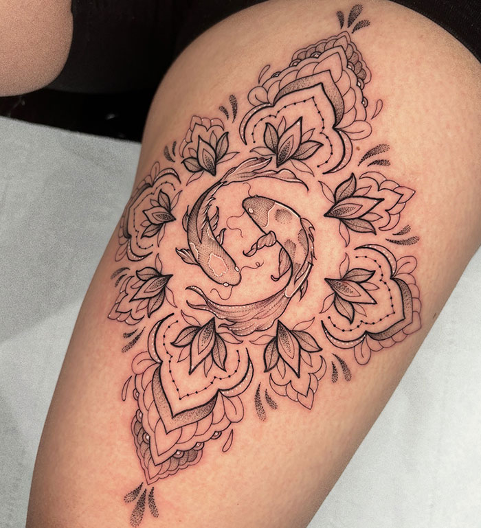 Intricate mandala tattoo with koi fish design on thigh, showcasing detailed artistry and symbolizing harmony.