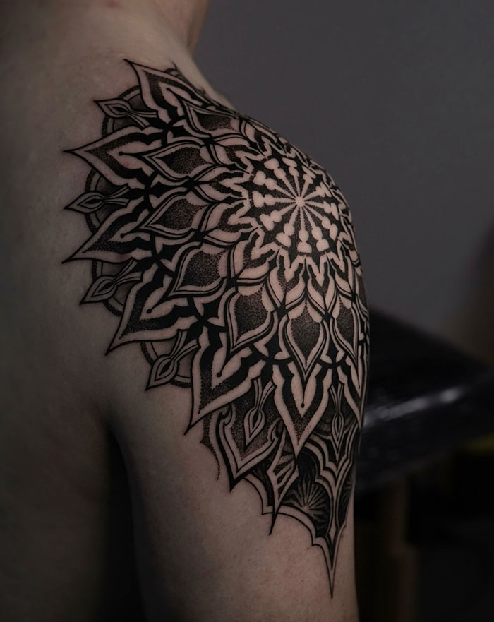 Mandala tattoo on shoulder featuring intricate black patterns and details.