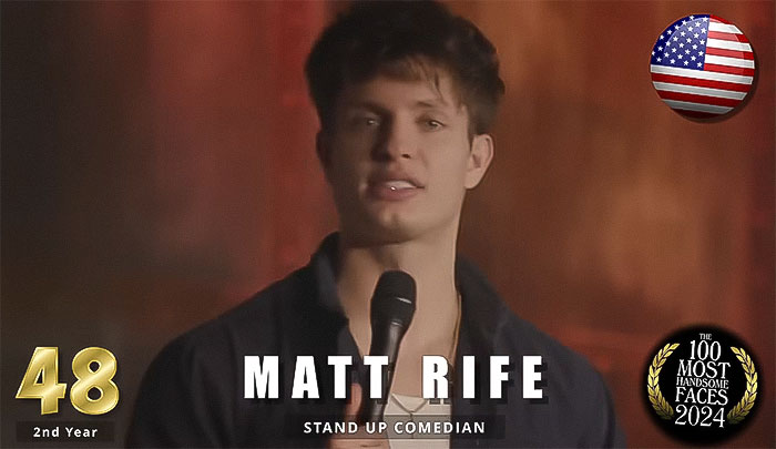 Stand-up comedian holding a microphone, ranked among the most handsome men of 2024 by The Independent Critics.