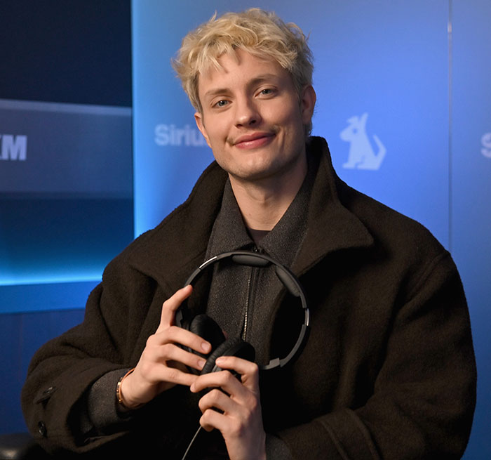 Blonde Matt Rife holding headphones, appearing on SIRIUS X FM radio show