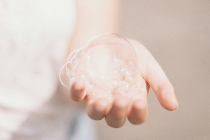 Hand holding soap bubble, illustrating a health myth concept debunked by medical professionals.
