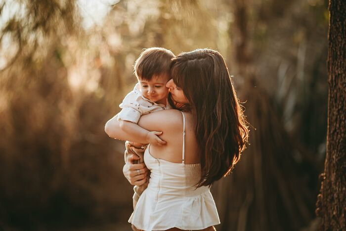 A woman holding a baby outdoors, conveying themes of pregnancy stress during the Christmas season.