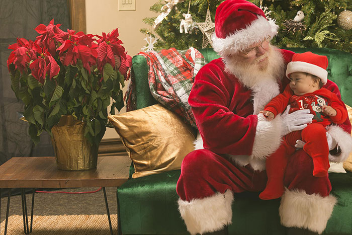 Santa holding a baby in a festive setting, capturing a special first moment. Santa holding a baby in a festive setting, capturing a special first moment.