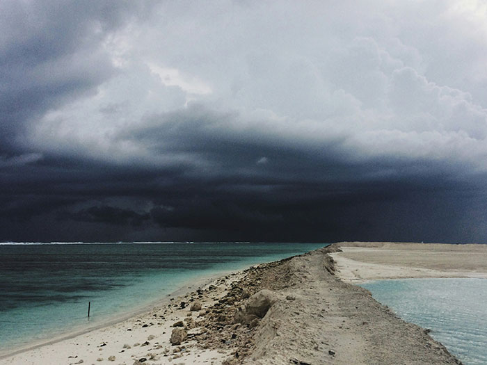 Stormy skies over a beach, with dark clouds gathering, creating an intense and dramatic scene.