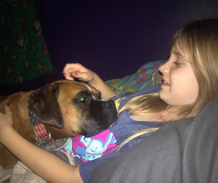 Young atalie Rupnow lying on a bed with a dog. Young atalie Rupnow lying on a bed with a dog.