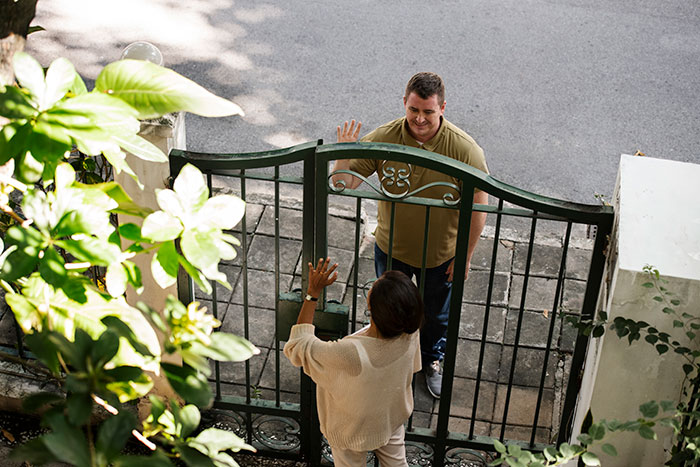 Person talking to a neighbor through a gate, highlighting a dispute over noise.