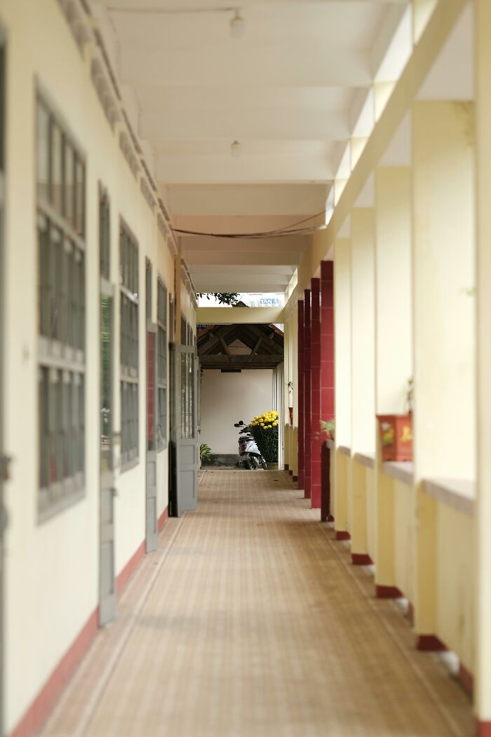 Quiet corridor with a motorbike at the end, suggesting everyday normality that may seem dated in future years.