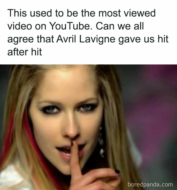 Young woman with finger on lips, reminiscent of nostalgic childhood shows, sharing a secretive gesture.