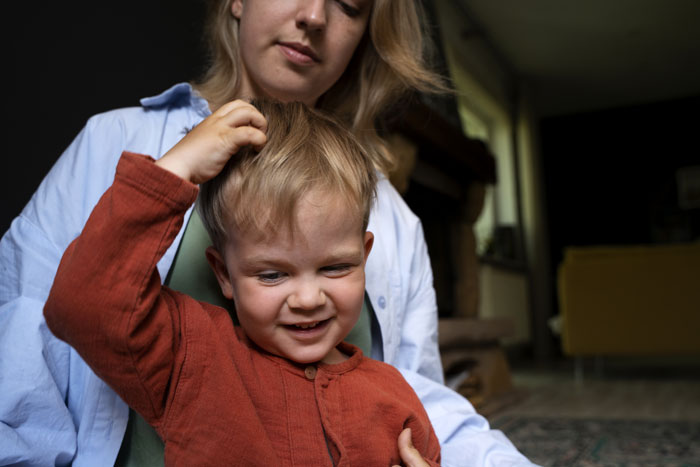 Person holding a smiling toddler, conveying parental concern for child safety.