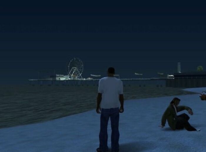 A person stands on a digital beach at night, evoking old-internet-feel with a Ferris wheel glowing in the background.