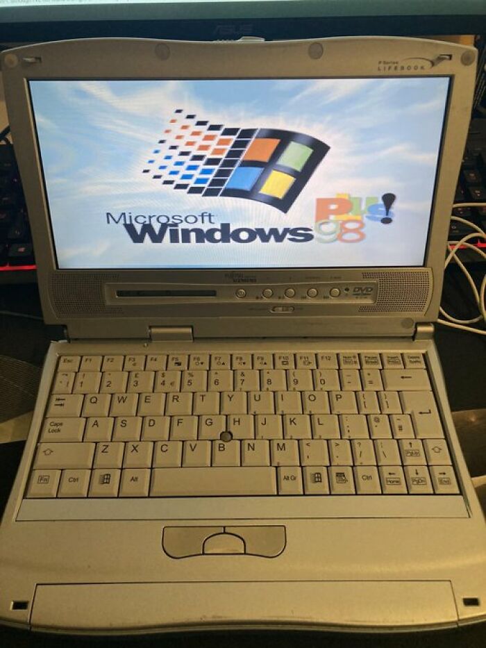 Retro laptop displaying Windows 98 startup screen, reminiscent of old internet feel.