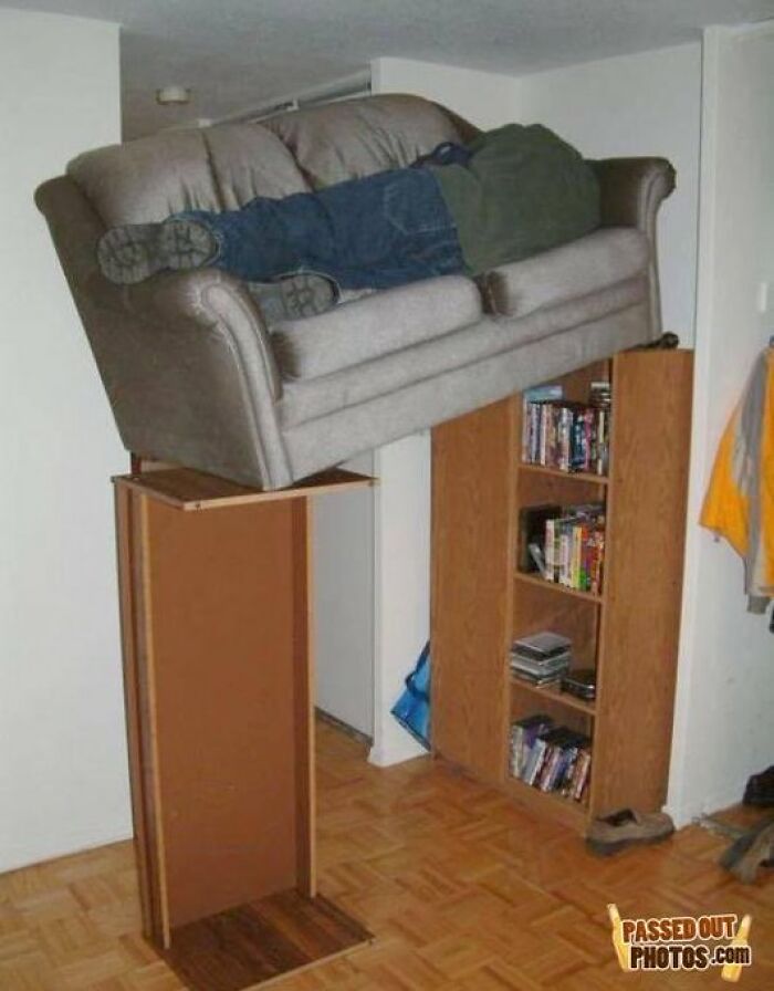 Man asleep on a precariously balanced sofa above shelving, capturing an old-internet-feel funny moment.
