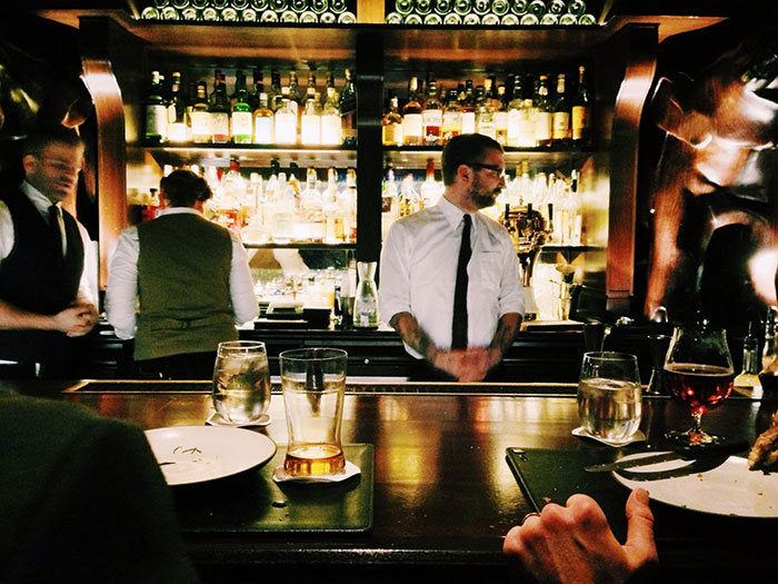 Bartender at a cozy bar, a popular spot for people to share Hollywood secrets over drinks.
