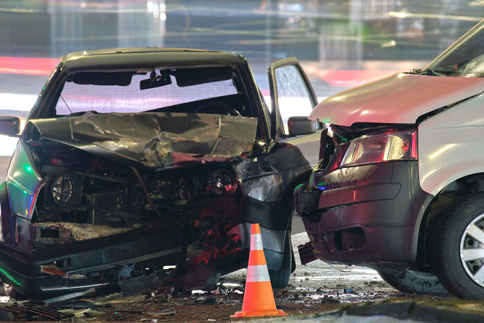 Two heavily damaged cars after an accident, highlighting people who survived against all odds.