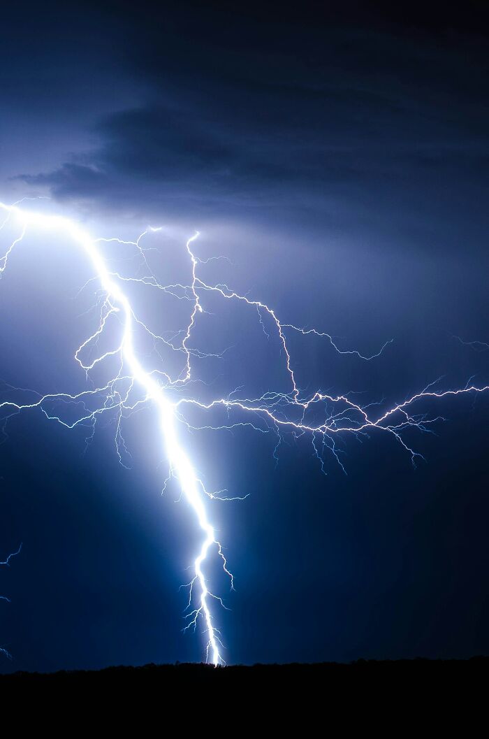 Lightning striking against a night sky, illustrating incredible luck in survival scenarios.
