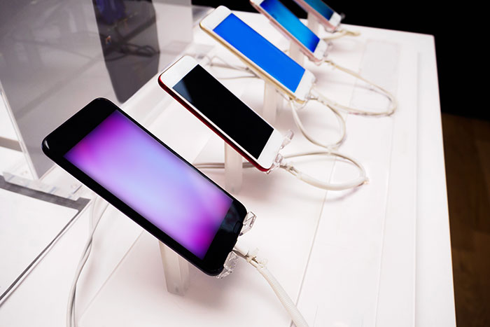 Smartphones displayed on a counter showcase technology used in jobs with little work involved.