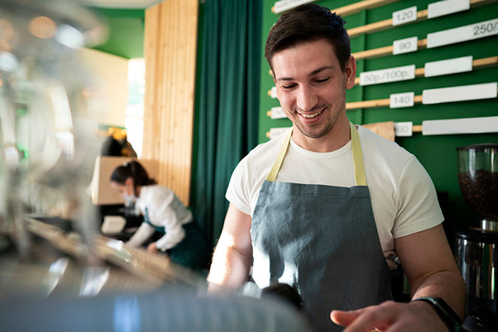 Barista smiling while making coffee, related to embarrassing moments theme.