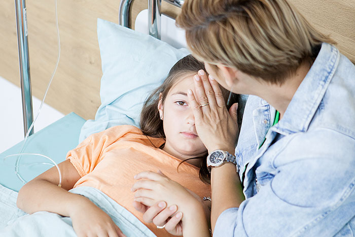 Person comforting a patient in a hospital bed, embodying themes of embarrassing moments and vulnerability.