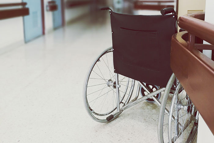Empty wheelchair in a hospital corridor symbolizing an embarrassing moment.