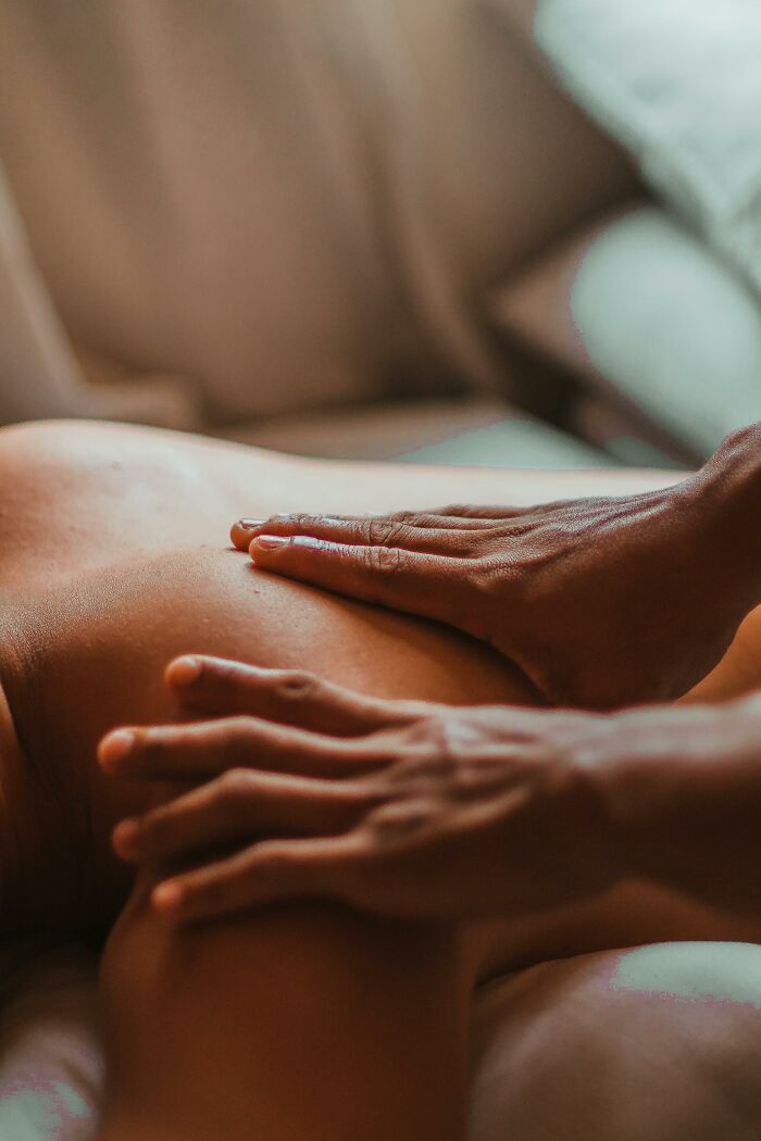 Hands giving a massage on a person's back, capturing a moment of relaxation and tranquility.
