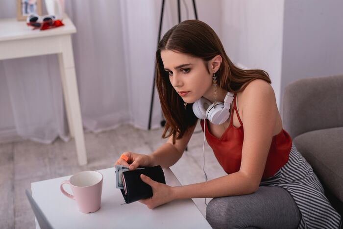 Woman with headphones sitting thoughtfully, representing best friends becoming strangers.