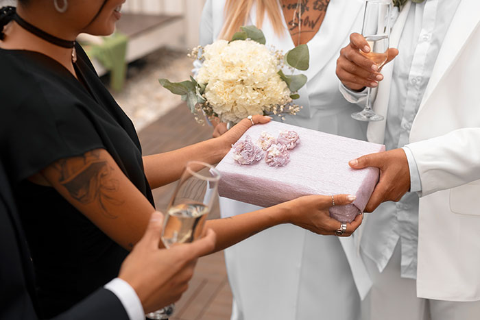 Person giving gift at a wedding, considering skipping due to gift expectations.