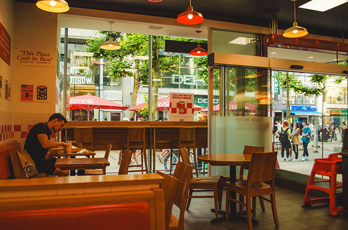 Man seated alone in a restaurant, emphasizing tipped service response over cold food.