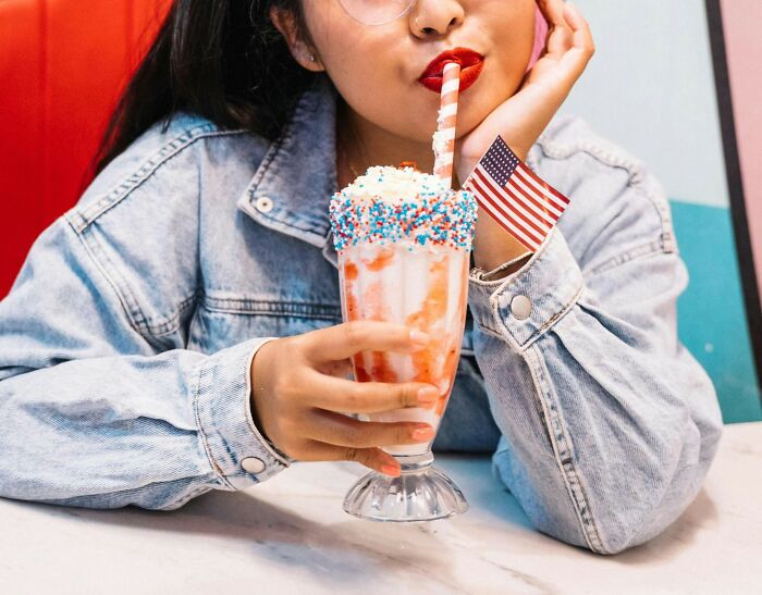 Woman enjoying a trendy milkshake with sprinkles, embodying Pinterest's 2025 predictions for future trends.