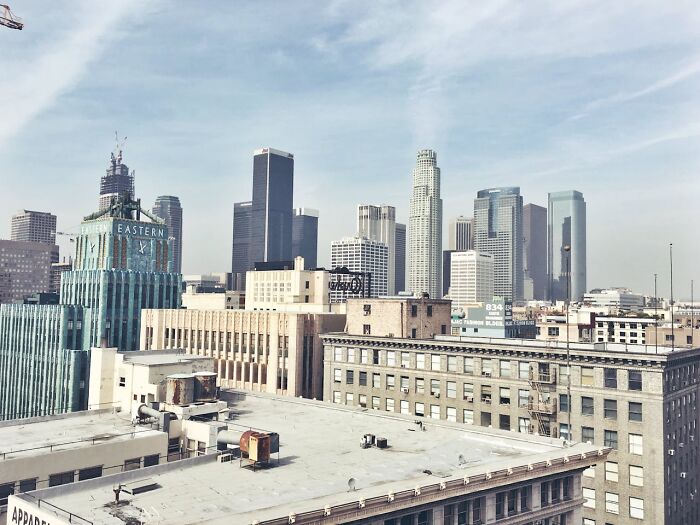 Downtown city skyline under clear sky, featuring unusual architectural designs and tall buildings.
