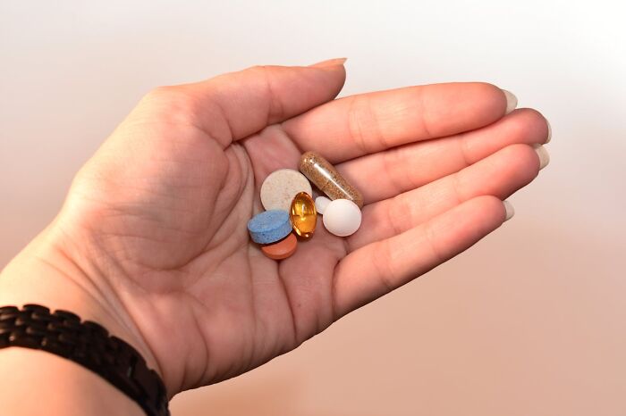A hand holding various pills, symbolizing health myths debunked by medical professionals.