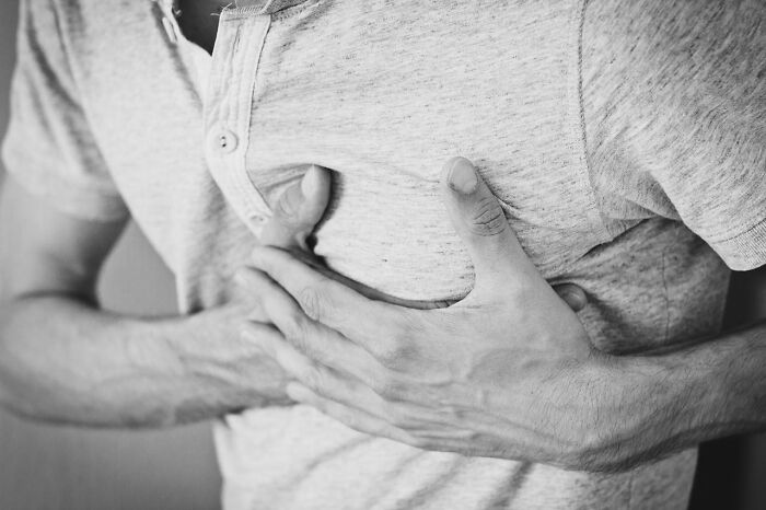 Person clutching chest in discomfort, illustrating common health myths discussed by medical professionals.