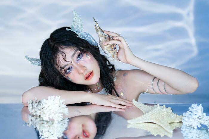 Woman posing with seashells in an ethereal setting, representing Pinterest's yearly predictions and upcoming trends for 2025.
