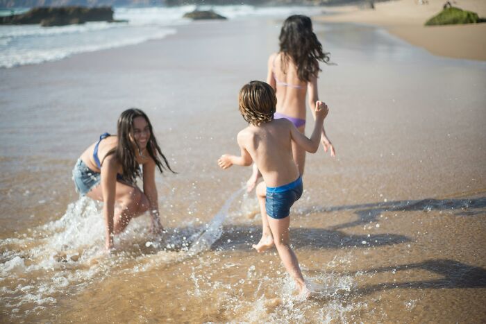 People enjoying a beachfront experience, playing in the surf on a sunny day.