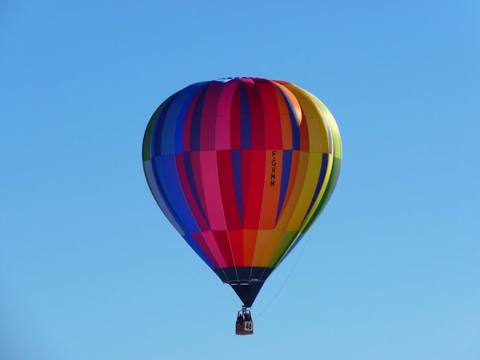 Colorful hot air balloon floating against a clear blue sky, representing a bold adventure choice.